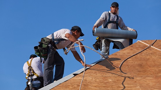 Mexican roofers installing roofing tiles