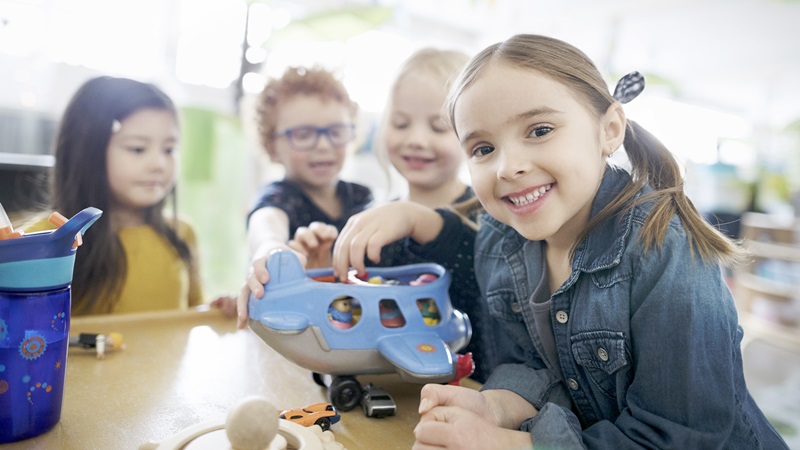 Early care in Billings, young children with airplane toy, 3 column
