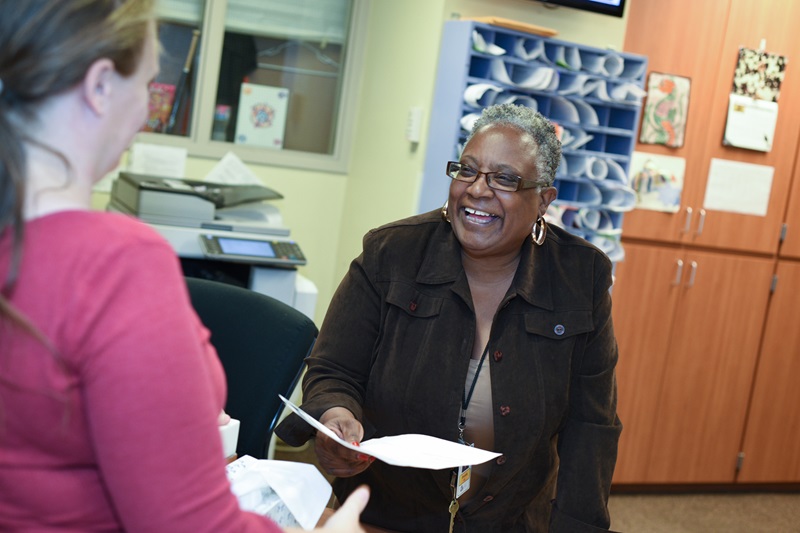 At the People Serving People shelter, a staff member helps a guest at the front desk.