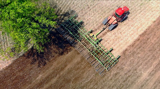 Aerial view of a tractor tilling a field