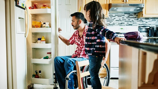 A father and daughter look into their refrigerator