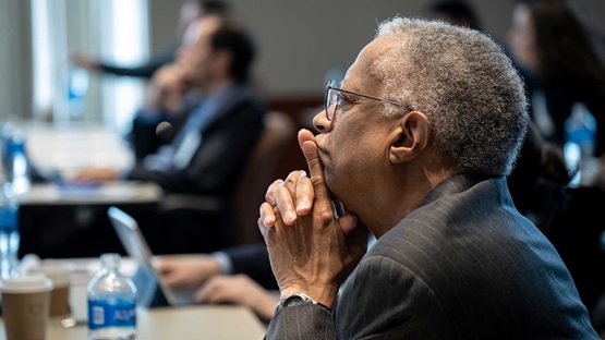 A photo of man (William Spriggs) in the audience at a conference