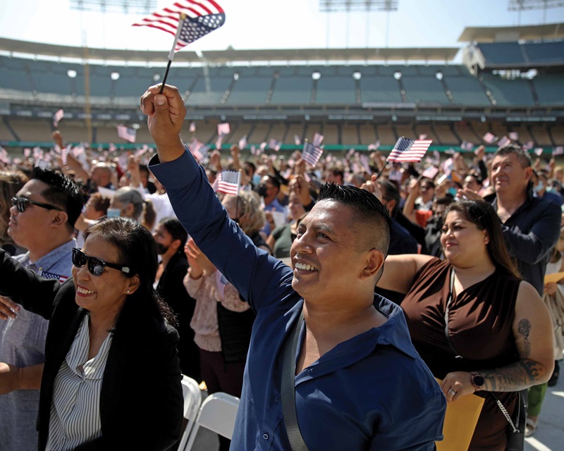 Waving a flag in a crowd of people at a naturalization ceremony