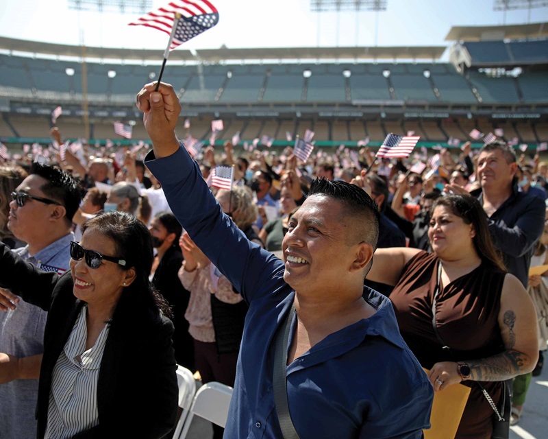 Waving a flag in  a crowd of people at a naturalization ceremony