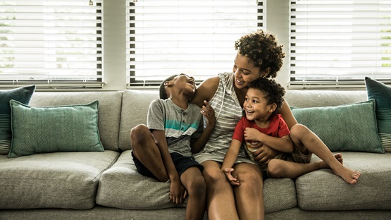 African American mother playing with two kids on the couch