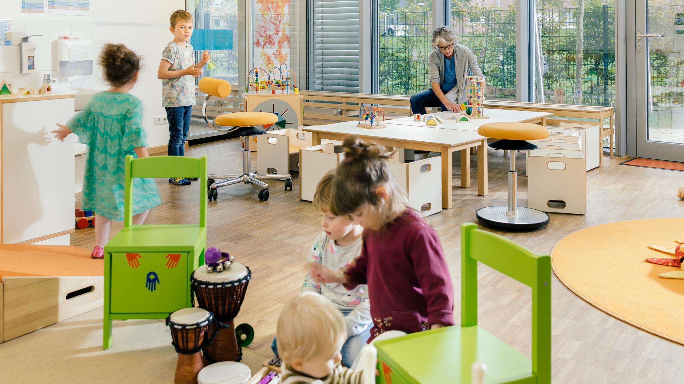 Bright and spacious preschool classroom with five students and a teacher
