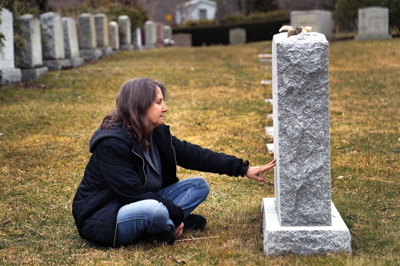 Photo of woman sitting at grave