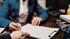 Closeup of two people reviewing and signing a legal document