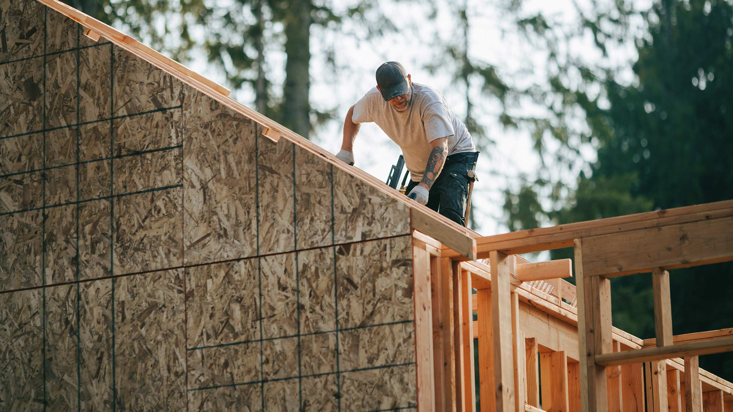 Construction worker framing a house's roof