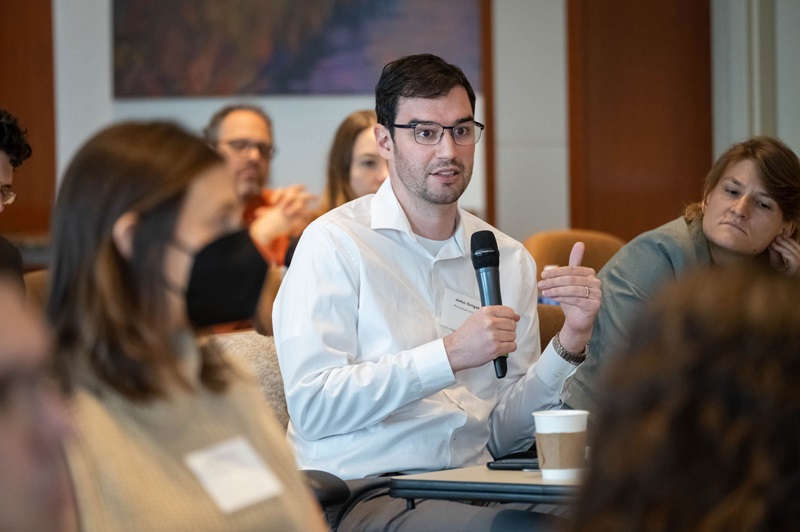 Three attendees talking between panels