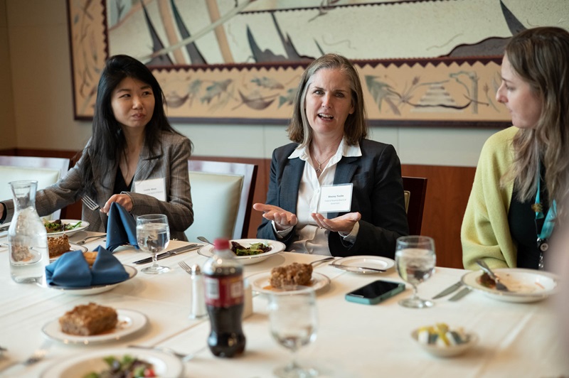 Three attendees talking at lunch