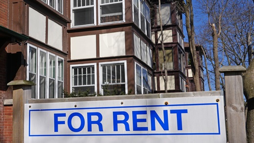 Apartment building with 'for rent' sign out front