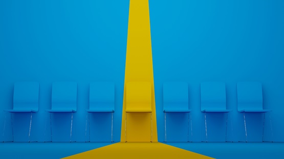 Blue chairs against a blue wall with one yellow chair highlighted