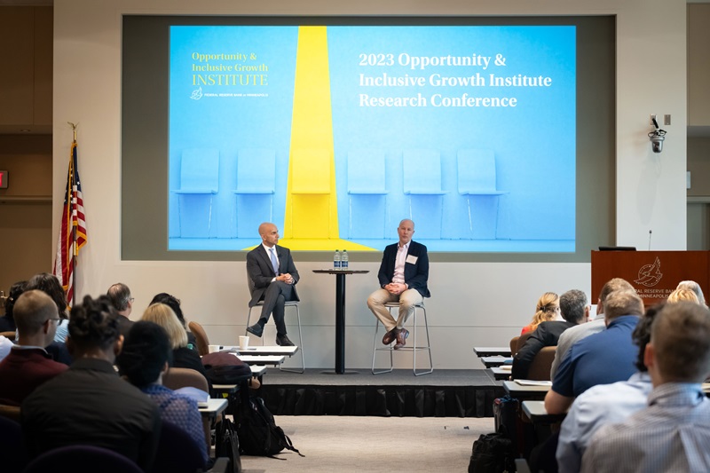 Two people presenting on stage in front of an audience