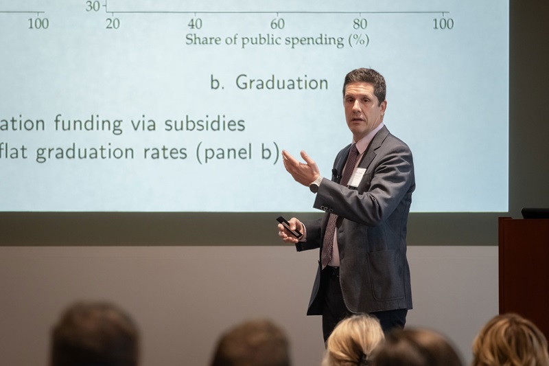 A presenter with his slides behind