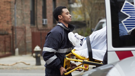 A paramedic loading a patient into an ambulance