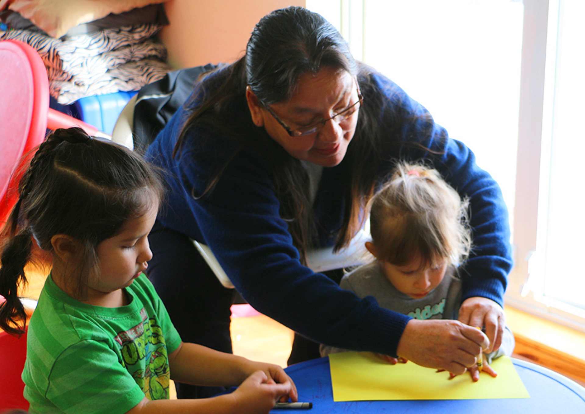 An instructor leads children through a drawing exercise at Lakota Immersion Childcare