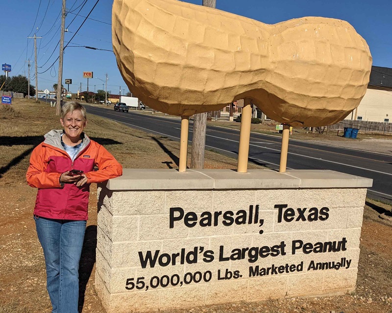 Woman smiling in front of Texas peanut sign