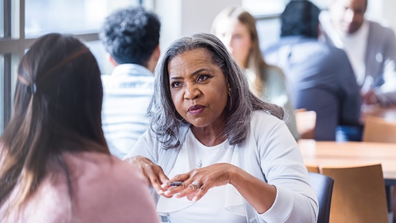A female employer sits across a table from a potential job applicant